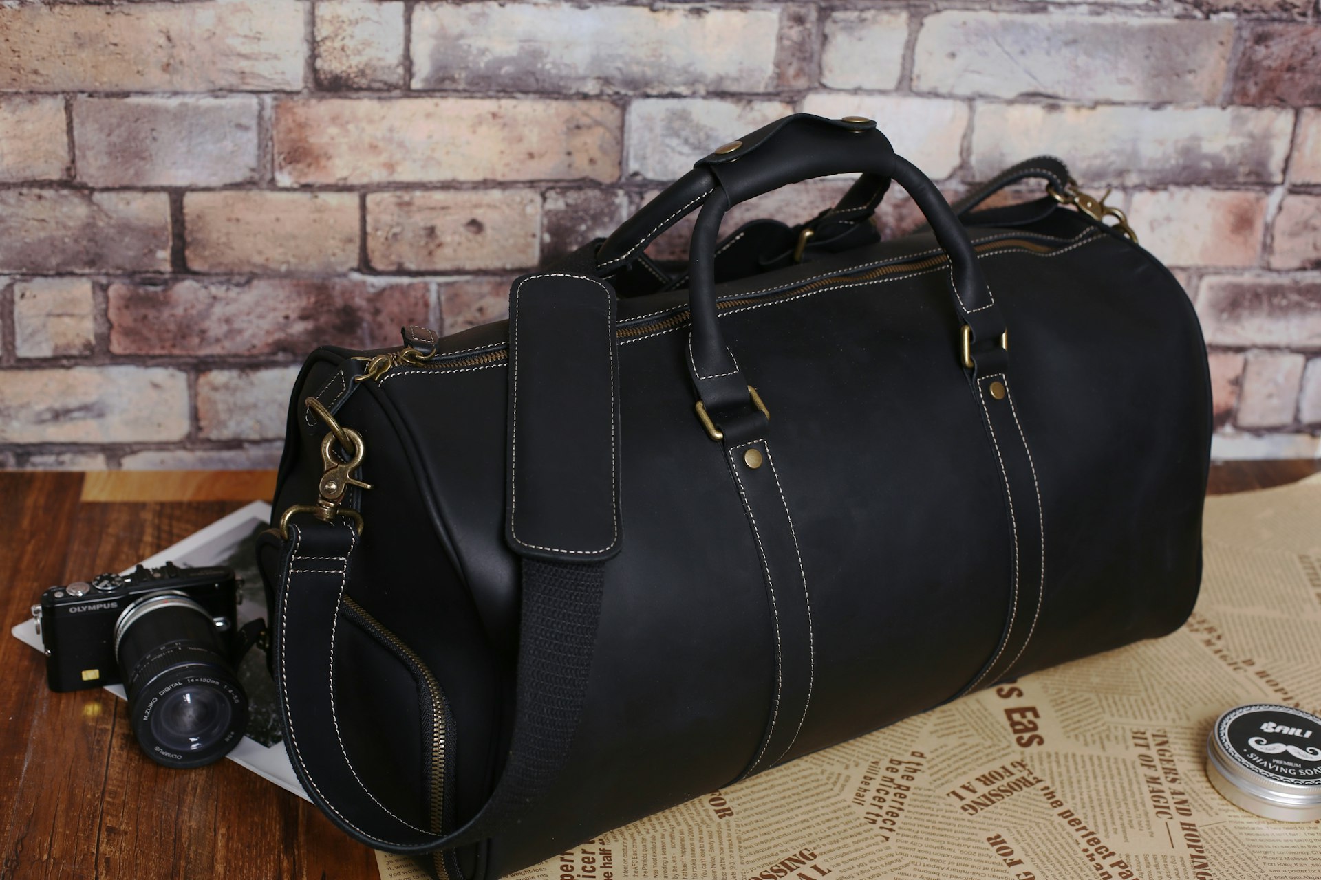a black leather duffel bag sitting on top of a table